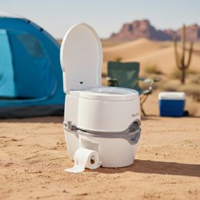 a white portable toilet near a desert campsite.